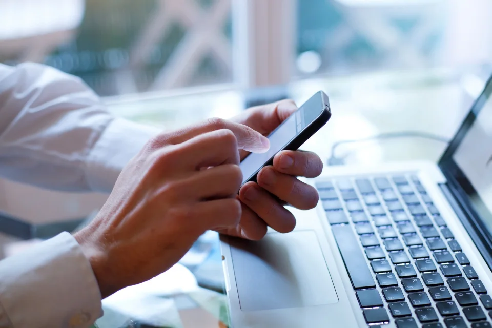 Consumidor com celular nas mãos